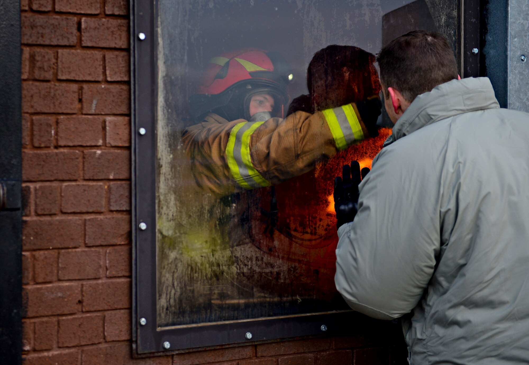 Col. Robert Novotny, 48th Fighter Wing commander, peers inside a structure fire training building at Royal Air Force Lakenheath, England, Jan. 16, 2015. Firefighters assigned to the 48th Civil Engineer Squadron conduct scenario exercises in order to stay proficient in their skills. (U.S. Air Force photo by Senior Airman Erin O’Shea/Released) 