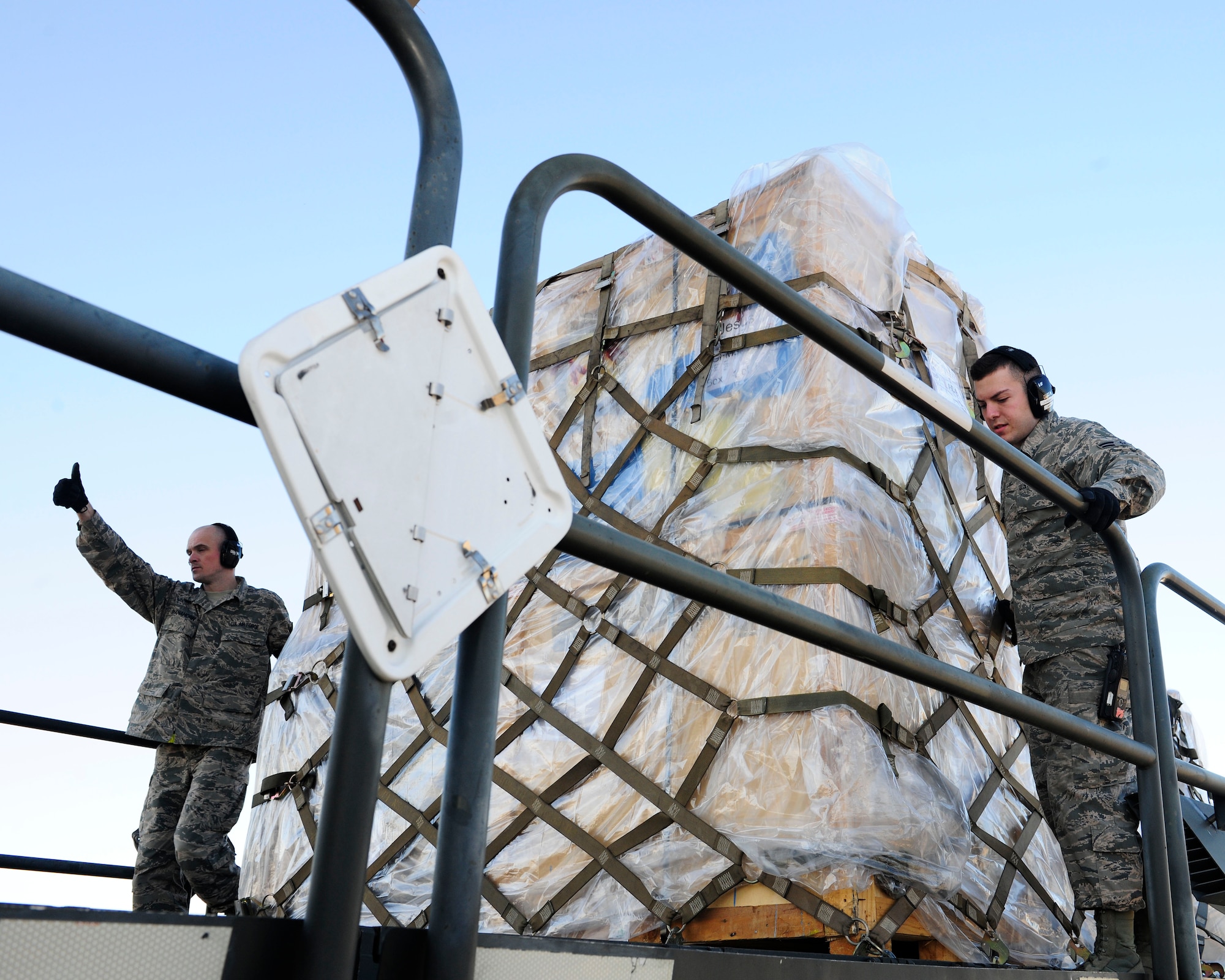 Staff Sgt. Andrew Shanahorn, 728th Air Mobility Squadron aircraft services supervisor, and Airman 1st Class Zack Lonza, 728th AMS aircraft services journeyman, unload pallets from an aircraft Jan. 14, 2015, at Incirlik Air Base, Turkey. Shanahorn and Lonza transport various cargo to and from aircrafts that land at Incirlik. (U.S. Air Force photo by Senior Airman Krystal Ardrey/Released)
