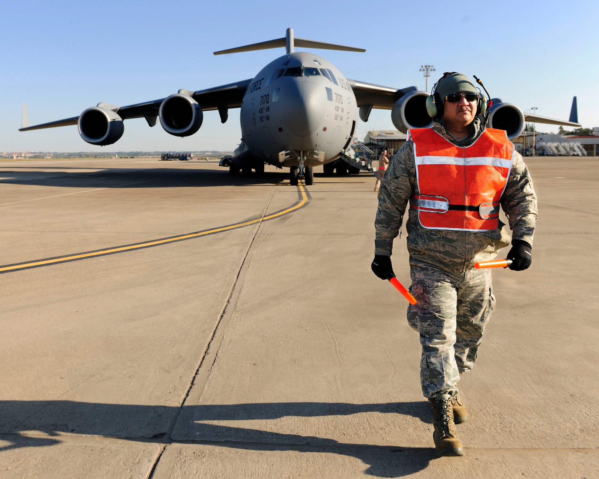 Master Sgt. Robert Farrell, 446th Aircraft Maintenance Operations Squadron electronic and environmental technician, prepares to marshal a C-17 Globemaster III for takeoff Jan. 14, 2015, at Incirlik Air Base, Turkey. Farrell is an augmentee reservist working with the 728th Air Mobility Squadron. (U.S. Air Force photo by Senior Airman Krystal Ardrey/Released)