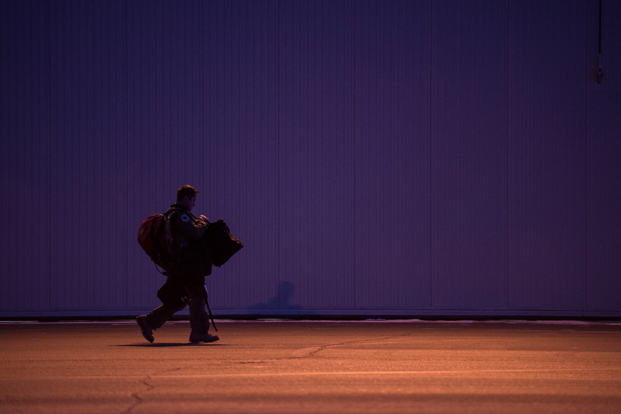 A U.S. Air Force F-16 Fighting Falcon pilot assigned to the 18th Aggressor Squadron (AS) walks to his hangar bay on Eielson Air Force Base, Alaska, Jan. 17. 2015.  More than 150 maintainers will keep the 18th AS in the air during Pacific Air Forces exercises, which are meant to prepare U.S. Airmen, Sailors and Marines along with coalition partners in the Pacific theater of operations for contingency operations if the need arises. (U.S. Air Force photo by Senior Airman Peter Reft/Released)