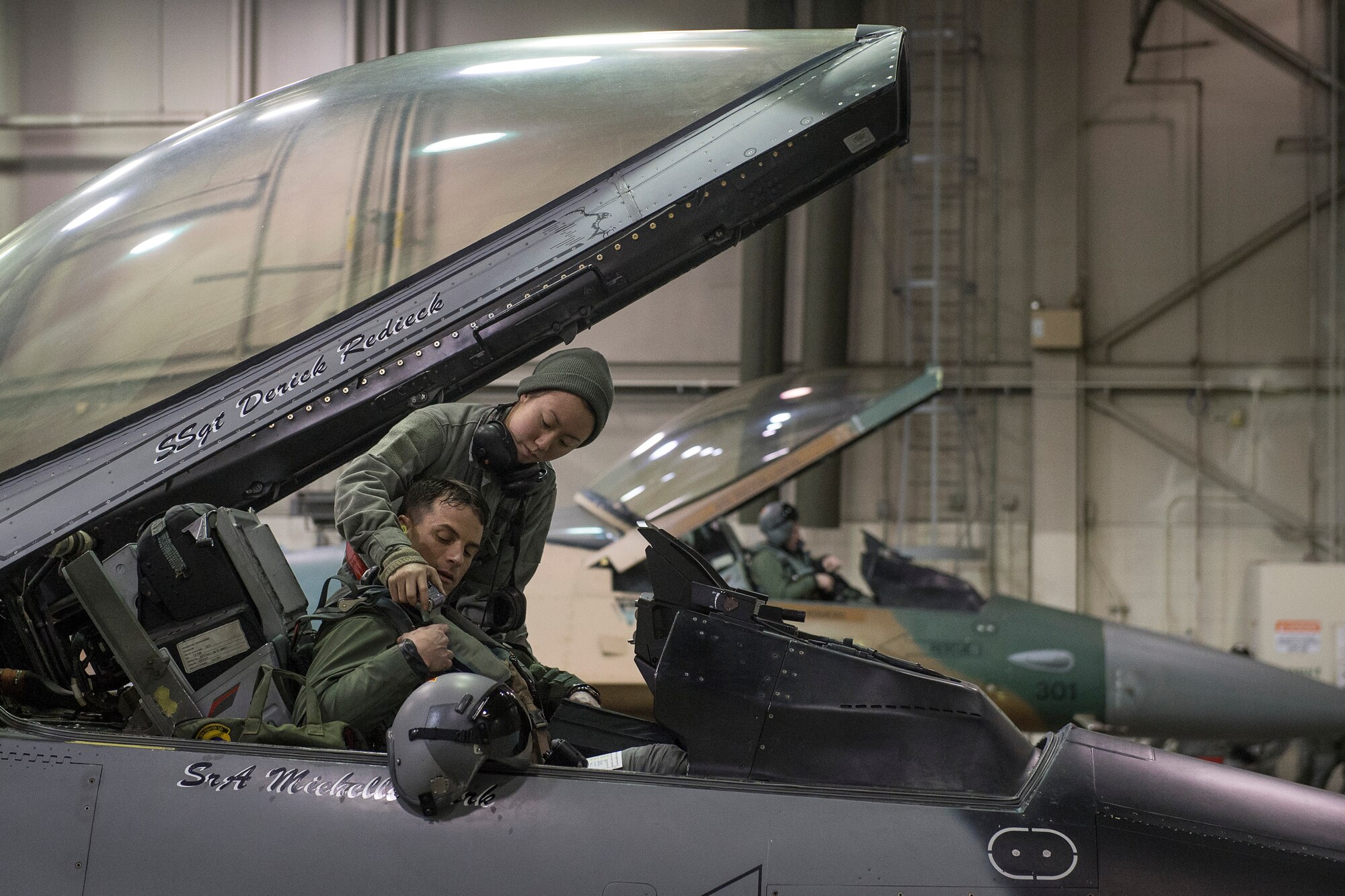 U.S. Air Force Senior Airman Michelle Park, a 354th Aircraft Maintenance Squadron F-16 Fighting Falcon crew chief, assists Lt. Col. David Graham, the 18th Aggressor Squadron (AS) commander, into a cockpit on Eielson Air Force Base, Alaska, Jan. 17. 2015.  More than 150 maintainers will keep the 18th AS in the air during Pacific Air Forces exercises, which are meant to prepare U.S. Airmen, Sailors and Marines along with coalition partners in the Pacific theater of operations for contingency operations if the need arises. (U.S. Air Force photo by Senior Airman Peter Reft/Released)