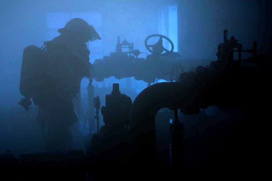 A Yokota firefighter searches a smoke-filled room during an Emergency Management Exercise at Yokota Air Base, Japan, Jan. 15, 2015.  The exercise evaluated the wing’s ability to respond and react to emergencies.   (U.S. Air Force photo by Osakabe Yasuo/Released)