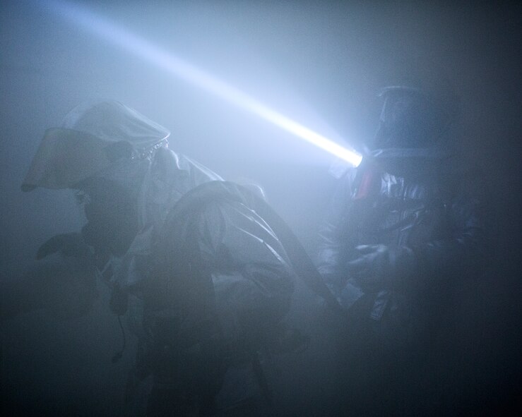Yokota firefighters search a smoke-filled room during an Emergency Management Exercise at Yokota Air Base, Japan, Jan. 15, 2015.  The exercise evaluated the wing’s ability to respond and react to emergencies. (U.S. Air Force photo by Osakabe Yasuo/Released) 