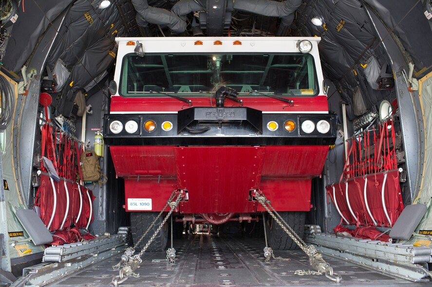 Loadmasters from the 36th Airlift Squadron secure a P-19 Aircraft Rescue Fire Fighting vehicle to the bed of a C-130 Hercules during a Samurai Readiness Inspection at Yokota Air Base, Japan, Jan. 14, 2015. The readiness inspection was designed to evaluate areas such a rapid mobility response to simulated contingencies. (U.S. Air Force photo by Osakabe Yasuo/Released)