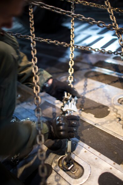 Senior Airman Dillon Howell, 36th Airlift Squadron loadmaster, secures a P-19 Aircraft Rescue Fire Fighting vehicle inside a C-130 Hercules at Yokota Air Base, Japan, Jan. 14, 2015. Loadmasters are an essential part of the loading and unloading of airlift transportation, providing secure cargo holds for pilots during missions.  (U.S. Air Force photo by Osakabe Yasuo/Released)
