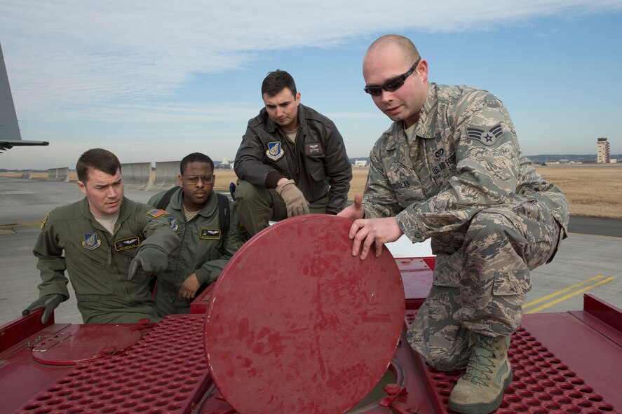 Senior Airman Jonathan Douglas, 374th Civil Engineer Squadron firefighter/vehicle operator, shows a water tank to loadmasters at Yokota Air Base, Japan, Jan. 14, 2015, during a Samurai Readiness Inspection.  The loadmasters made sure the water tank was empty before loading it onto a C-130 Hercules. (U.S. Air Force photo by Osakabe Yasuo/Released)