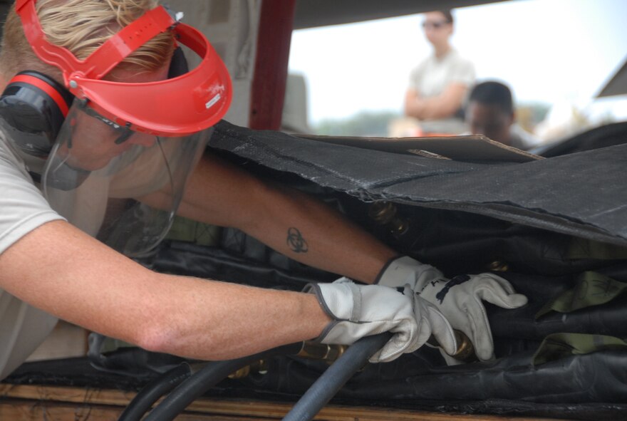 Air Force Staff Sgt. David Long, a maintainer with the 154th AMXS, connects an airbag lifting system in preparation to lift an F-4 jet at Kalealoa Airport, Hawaii, Jan 14, 2015. The lifting of the F-4 jet was part of a Crash, Damage, Disabled Aircraft Recovery or CDDAR training exercise. (Hawaii Air National Guard photo/Senior Airman Orlando Corpuz)


