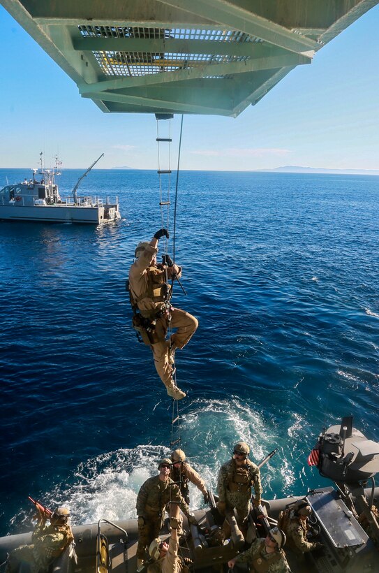 A Marine climbs a caving ladder to board a gas and oil platform during maritime interoperability training off the coast of Santa Barbara, Calif., Jan. 16, 2015.