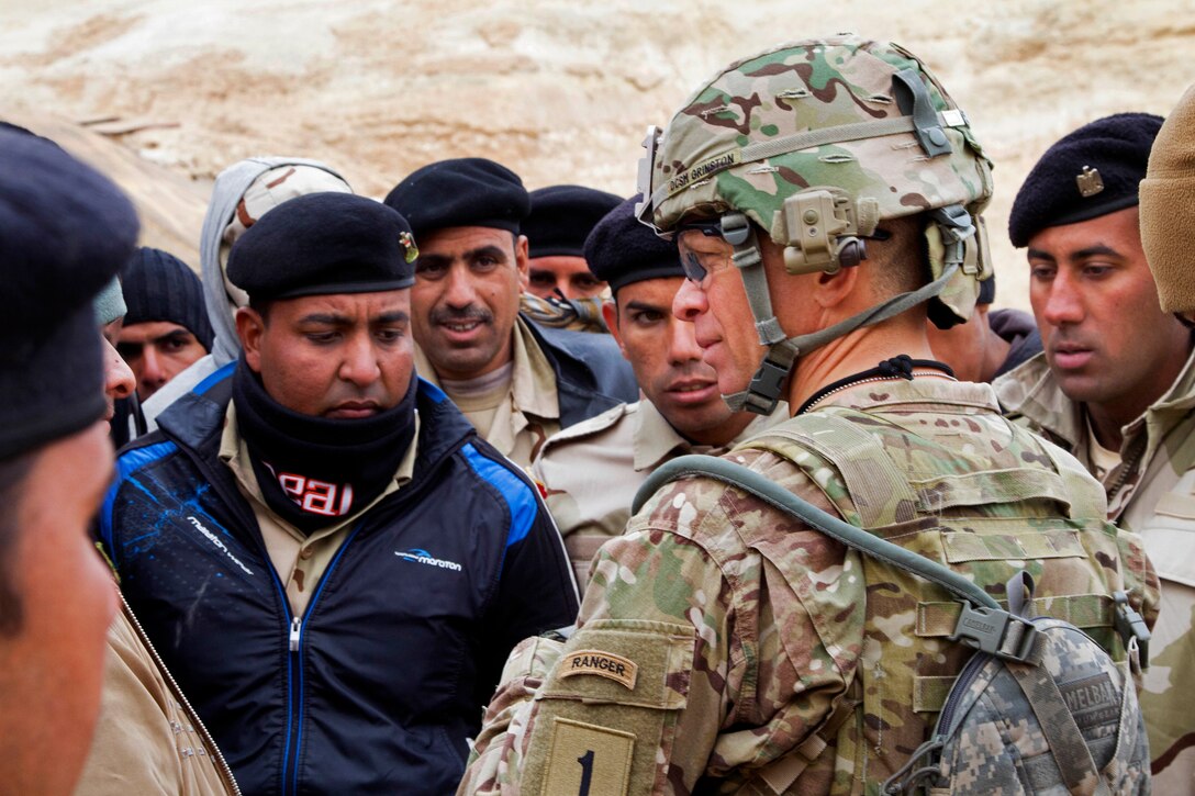 U.S. Army Command Sgt. Maj. Michael A. Grinston, right foreground, talks to Iraqi army soldiers about their training experience and living conditions on Al Asad Air Base, Iraq, Jan. 15, 2015. Grinston is the senior enlised advisor assigned to the 1st Infantry Division, and is helping to develop the training program for Iraqi army battalions training throughout Iraq with the assistance of coalition forces.