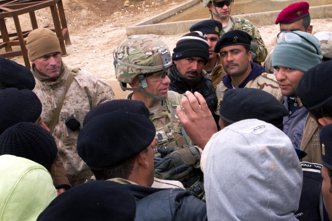 U.S. Army Command Sgt. Maj. Michael A. Grinston, center, talks to Iraqi army soldiers about their training experience and living conditions on Al Asad Air Base, Iraq, Jan. 15, 2015. Grinston is the senior enlised advisor assigned to the 1st Infantry Division.