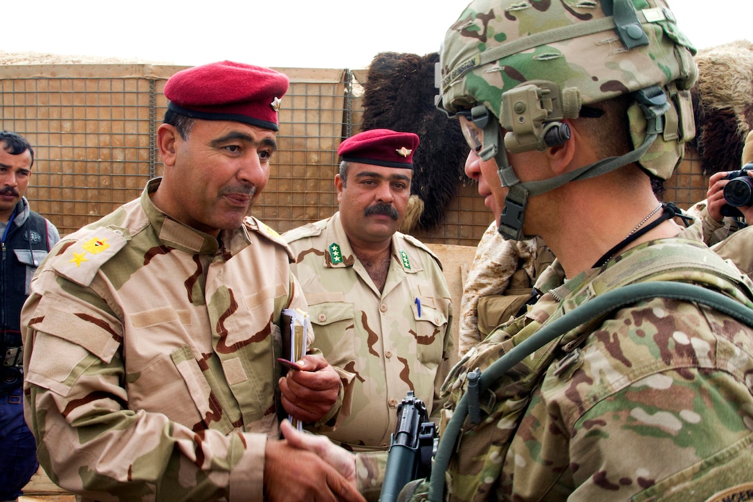 U.S. Army Command Sgt. Maj. Michael A. Grinston, foreground, presents a ...