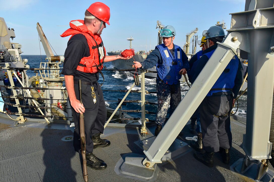 U.S. Navy Seaman Logan Utnage, right, returns the shot line to U.S. Navy Petty Officer 2nd Class Nicholas Speth on the deck of the guided-missile destroyer USS Gridley during a replenishment at sea with the Fleet Replenishment Oiler USNS Walter S. Diehl in the U.S. 5th Fleet area of operations, Jan. 13, 2015. The Gridley is deployed in support of Operation Inherent Resolve, strike operations in Iraq and Syria as directed, maritime security operations, and theater security cooperation efforts in the region.