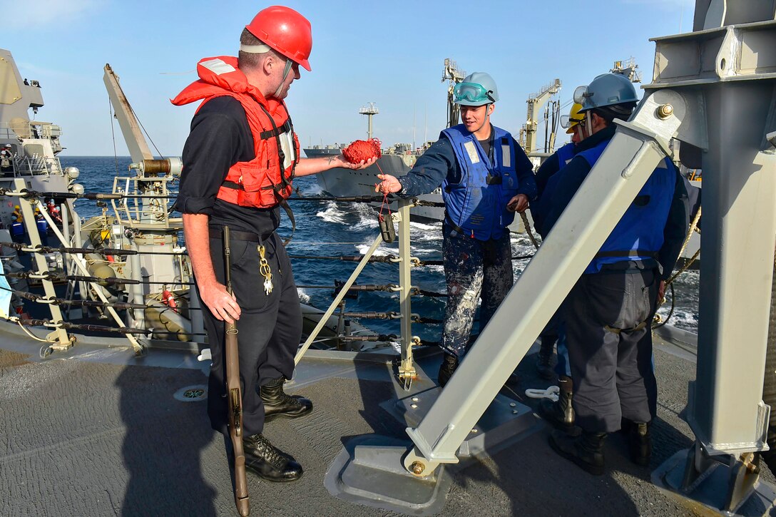 U.S. Navy Seaman Logan Utnage, right, returns the shot line to U.S ...