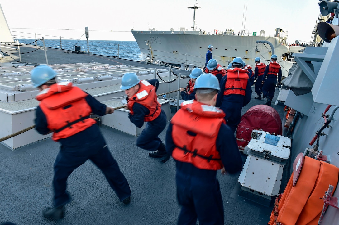 U.S. sailors on the deck of the guided-missile destroyer USS Gridley heave around a line during a replenishment at sea with the Fleet Replenishment Oiler USNS Walter S. Diehl in the U.S. 5th Fleet area of operations, Jan. 13, 2015, supporting Operation Inherent Resolve.