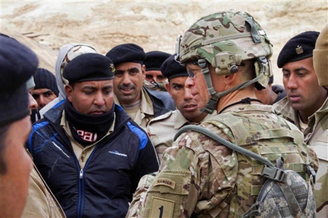 U.S. Army Command Sgt. Maj. Michael A. Grinston, right foreground, talks with Iraqi army soldiers about their training experience and living conditions on Al Asad Air Base, Iraq, Jan. 15, 2015. Grinston is the senior enlisted advisor assigned to the 1st Infantry Division. He is helping to develop the training program for Iraqi army battalions, assisted by coalition forces throughout Iraq.