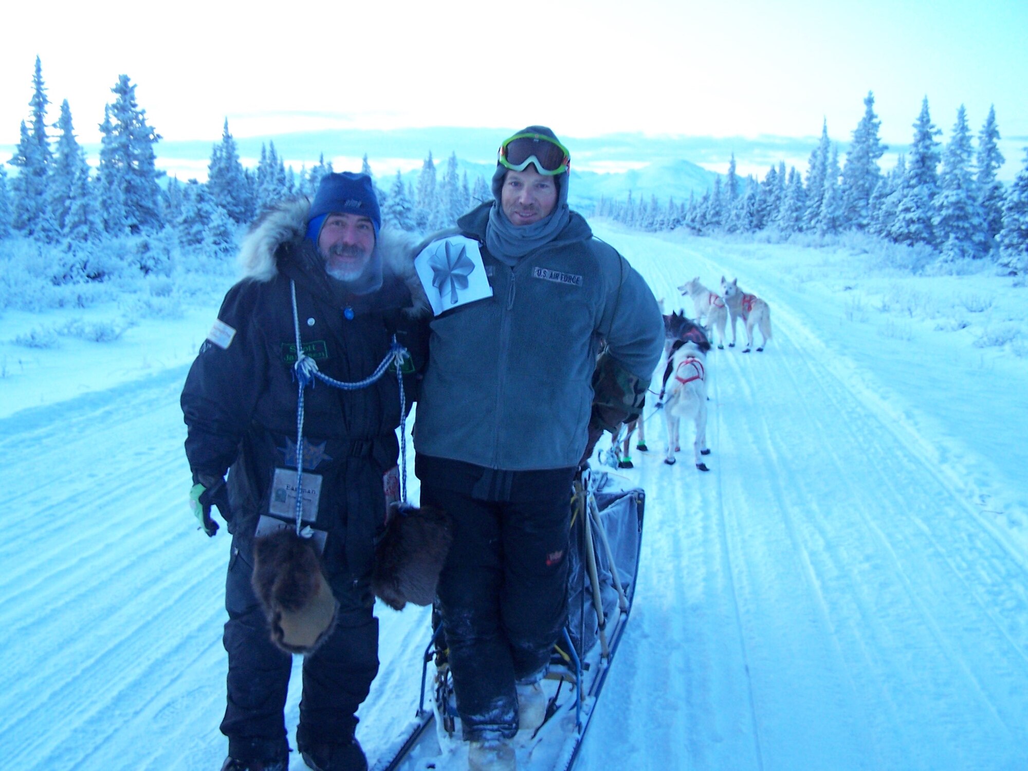 Scott Janssen  and Maj. Roger Lee pose for a photo while training to participate in the Trail Sled Dog Race in Alaska. Janssen befriended Lee and serves as his mentor. Lee is a 60th Aerospace Medicine Squadron bioenvironmental engineering operations officer. (Courtesy photo)