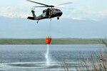 A flight crew from MNBG E aviation works together to safely fill a Bambi bucket during firefighting training recently held in  Kosovo.