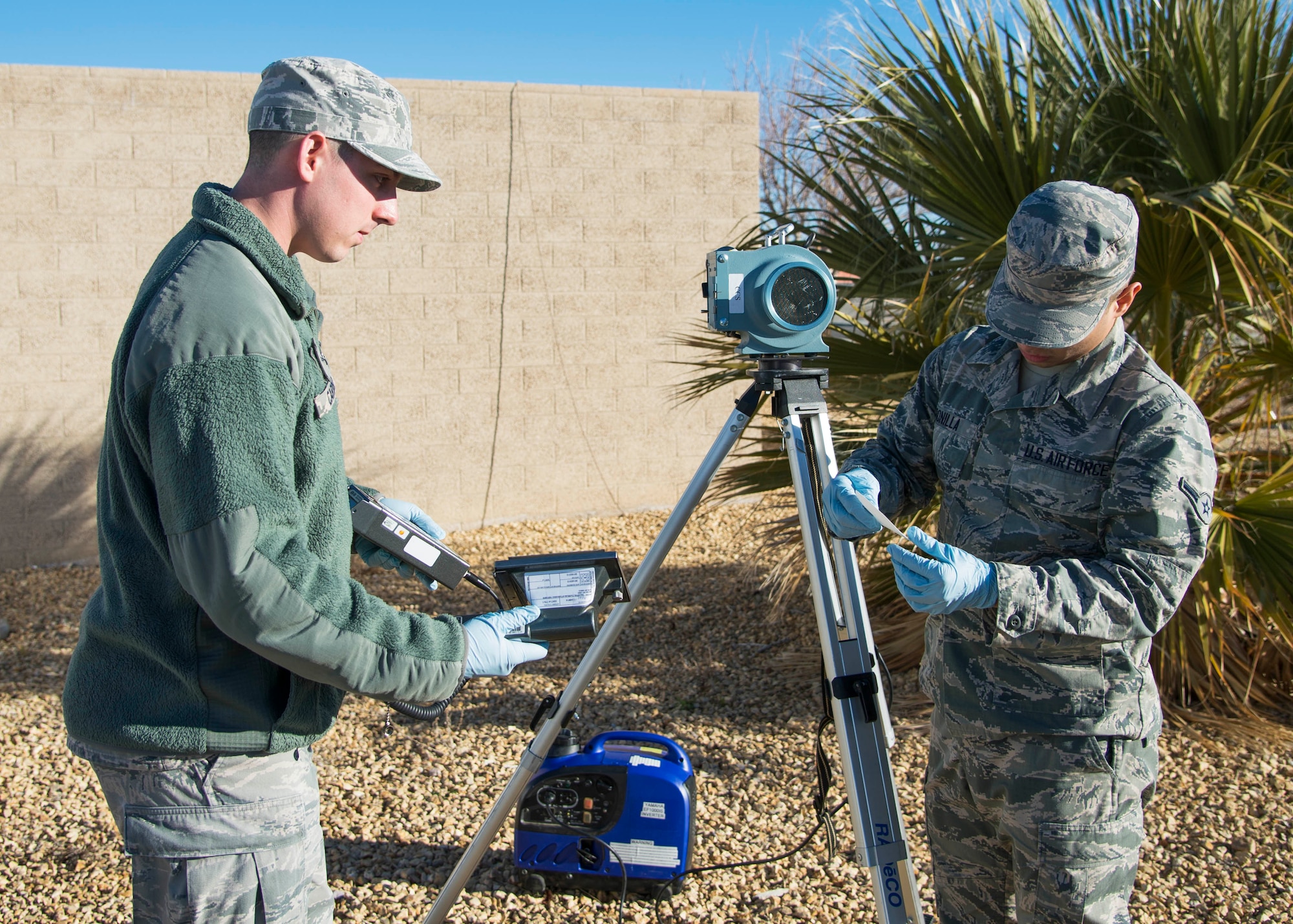 Biomedical Sciences Corps technicians Airman Juan Bonilla and Airman 1st Class Dane Carder use equipment designed to detect alpha radiation. Bonilla must remove a filter from a sampling device, to allow Carder to take radiation readings. While there is radiation everywhere, background readings are helpful in determining if an incident has added radiation to the environment. The readings can be used to determine public safeguards and employee protection to operate safely in the environment. (U.S. Air Force photo by Ethan Wagner)