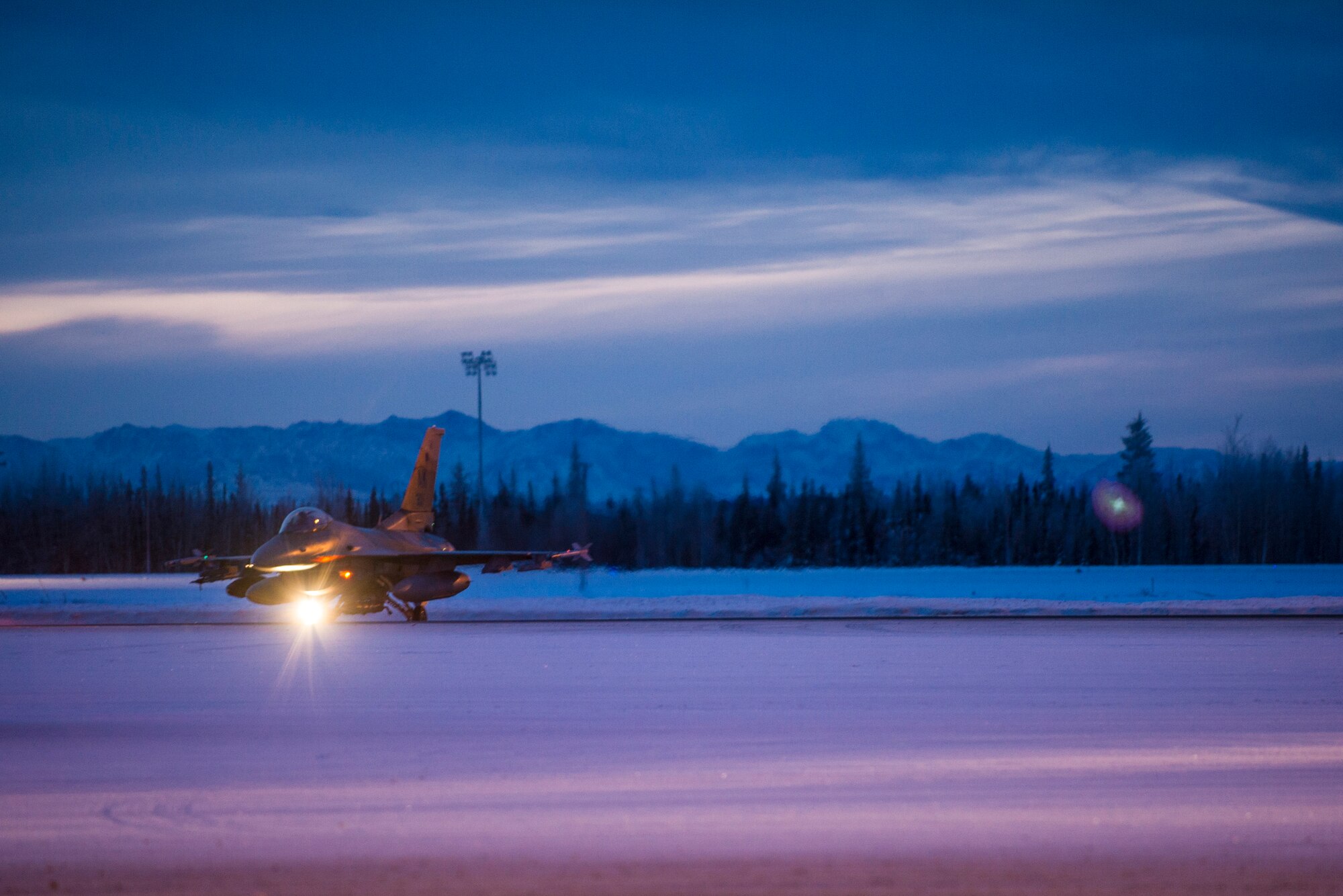 One of 14 U.S. Air Force F-16 Fighting Falcon aircraft with the 18th Aggressor Squadron taxis at Eielson Air Force Base, Alaska, Jan. 17, 2015, for travel to Joint Base Pearl Harbor-Hickam, Hawaii, and Andersen Air Force Base, Guam, to participate in Pacific Air Forces exercises. More than 150 maintainers will keep the Aggressors in the air during the exercises, which are meant to prepare U.S. Airmen, Sailors and Marines along with coalition partners in the Pacific theater of operations for contingency operations if the need arises. (U.S. Air Force photo by Staff Sgt. Joshua Turner/Released)