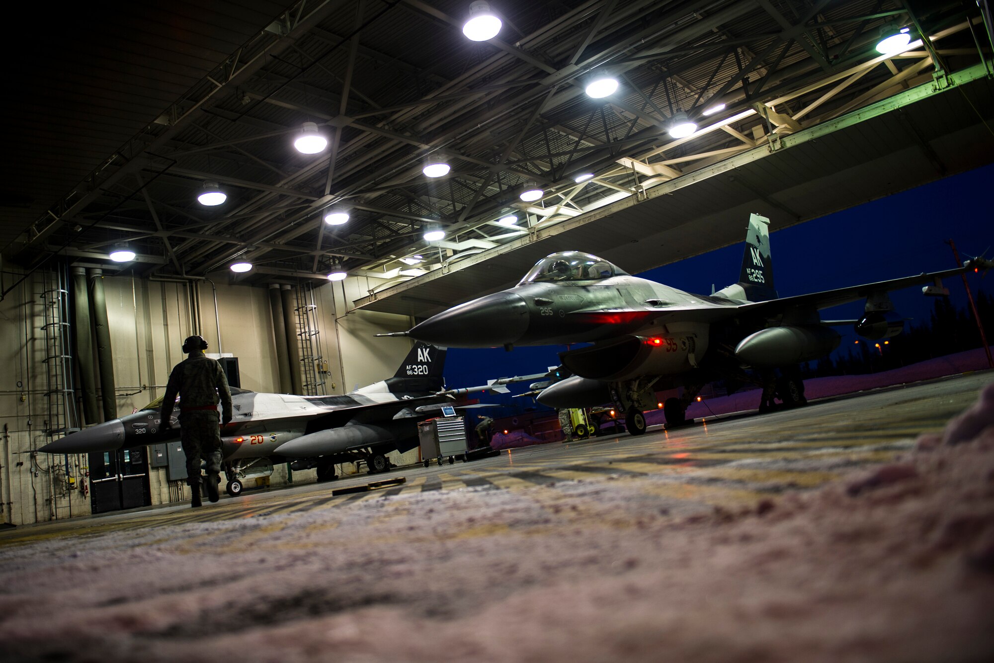 U.S. Air Force Senior Airman Nathaniel Moore, a crew chief assigned to the 354th Aircraft Maintenance Squadron, prepares an F-16 Fighting Falcon aircraft on Eielson Air Force Base, Alaska, Jan. 17, 2015, for travel to Joint Base Pearl Harbor-Hickam, Hawaii, and Andersen Air Force Base, Guam.  More than 150 maintainers will keep the 18th Aggressor Squadron in the air during Pacific Air Forces exercises, which are meant to prepare U.S. Airmen, Sailors and Marines along with coalition partners in the Pacific theater of operations for contingency operations if the need arises. (U.S. Air Force photo by Staff Sgt. Joshua Turner/Released)