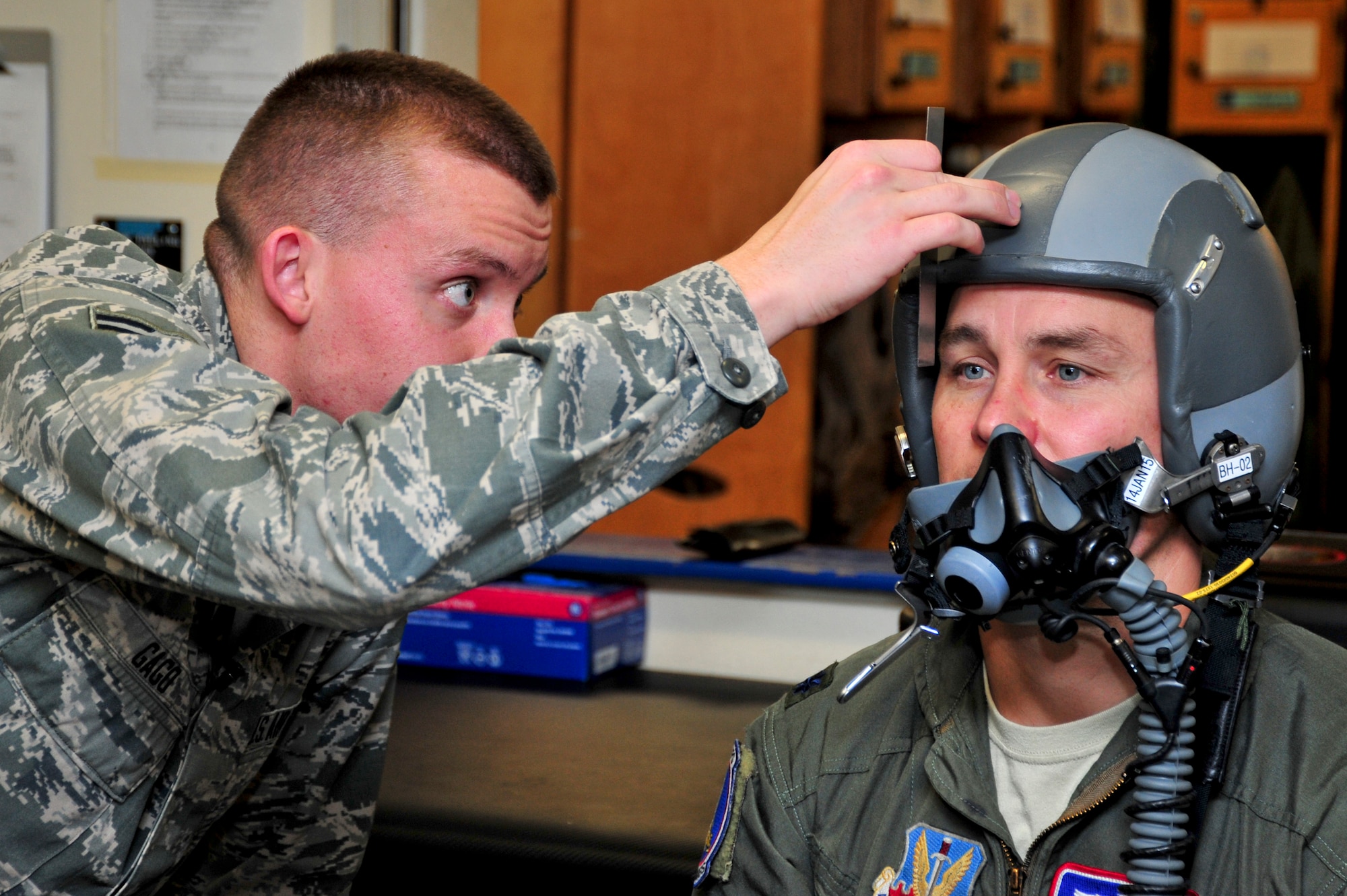 U.S. Air Force Airman 1st Class Joseph Gago, 355th Operations Support Squadron Aircrew Flight Equipment technician, measures the eye placement of Lt. Col. Aaron Redfern, 354th Fighter Squadron director of operations, during a fitting for a new helmet mounted integrated targeting system at Davis-Monthan Air Force Base, Ariz., Jan. 8, 2014.  The Scorpion Helmet Mounted Cueing System provides pilots with the ability to rapidly cue sensors or weapons and to designate targets with a high degree of accuracy by simply "looking at" the target or point of interest. (U.S. Air Force photo by Airman 1st Class Chris Massey/Released)