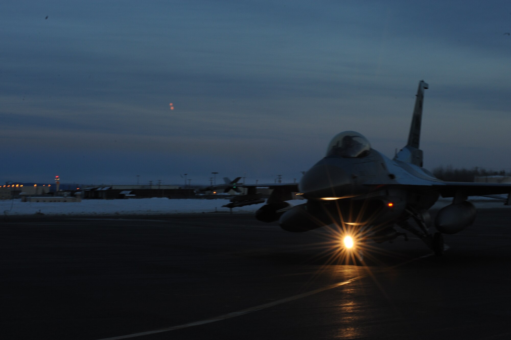 A U.S. Air Force F-16 Fighting Falcon aircraft assigned to the 18th Aggressor Squadron taxis to the runway before take-off from Eielson Air Force Base, Alaska, Jan. 17, 2015. The jets are in transit to Joint Base Pearl Harbor-Hickam, Hawaii, and Andersen Air Force Base, Guam, to participate in Pacific Air Forces exercises. More than 150 maintenance Airmen will keep the Aggressors in the air during the exercises which are meant to prepare U.S. Airmen, Sailors and Marines along with coalition partners in the Pacific theater of operations for contingency operations if the need arises. (U.S. Air Force photo by Staff Sgt. Kirsten Wicker/Released) 