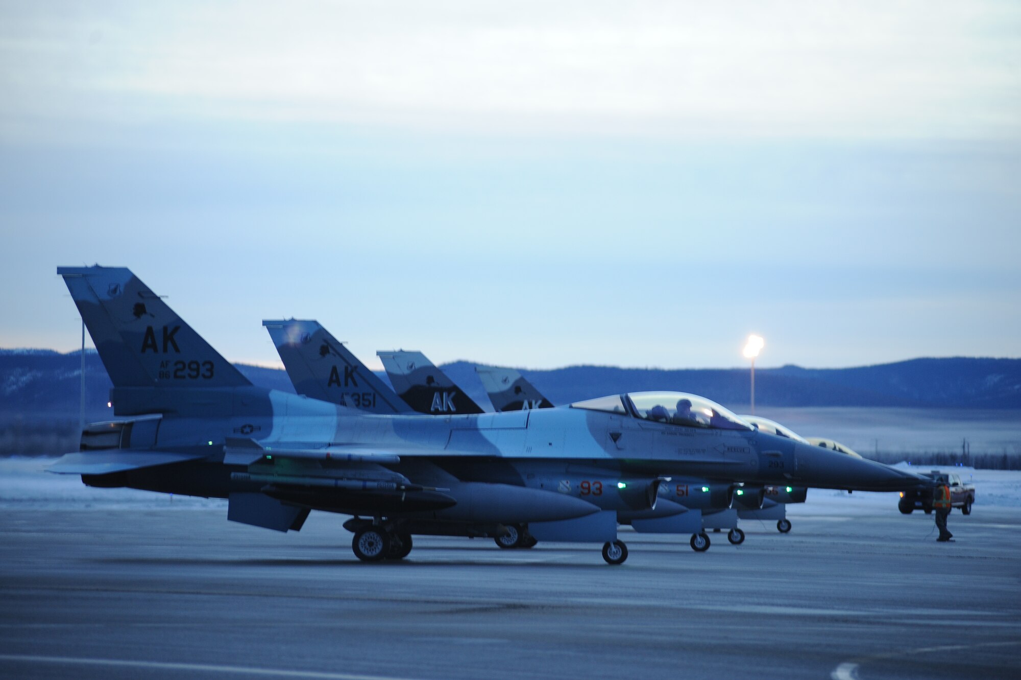 U.S. Air Force F-16 Fighting Falcon aircraft assigned to the 18th Aggressor Squadron prepare to take-off from Eielson Air Force Base, Alaska, Jan. 17, 2015. The jets are in transit to Joint Base Pearl Harbor-Hickam, Hawaii, and Andersen Air Force Base, Guam, to participate in Pacific Air Forces exercises. More than 150 maintenance Airmen will keep the Aggressors in the air during the exercises which are meant to prepare U.S. Airmen, Sailors and Marines along with coalition partners in the Pacific theater of operations for contingency operations if the need arises. (U.S. Air Force photo by Staff Sgt. Kirsten Wicker/Released) 