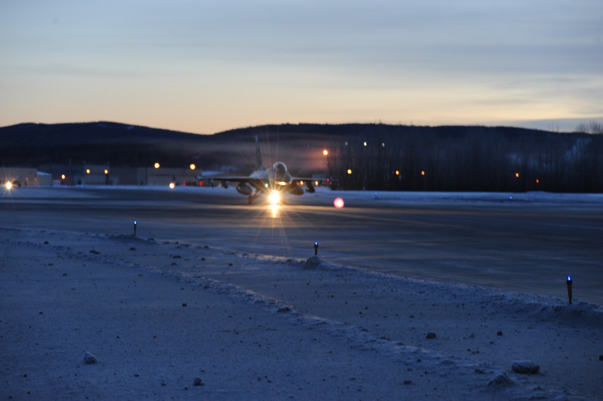 One of 14 U.S. Air Force F-16 Fighting Falcon aircraft assigned to the 18th Aggressor Squadron taxis to the runway before take-off from Eielson Air Force Base, Alaska, Jan. 17, 2015. The jets are in transit to Joint Base Pearl Harbor-Hickam, Hawaii, and Andersen Air Force Base, Guam, to participate in Pacific Air Forces exercises. More than 150 maintenance Airmen will keep the Aggressors in the air during the exercises which are meant to prepare U.S. Airmen, Sailors and Marines along with coalition partners in the Pacific theater of operations for contingency operations if the need arises. (U.S. Air Force photo by Staff Sgt. Kirsten Wicker/Released) 