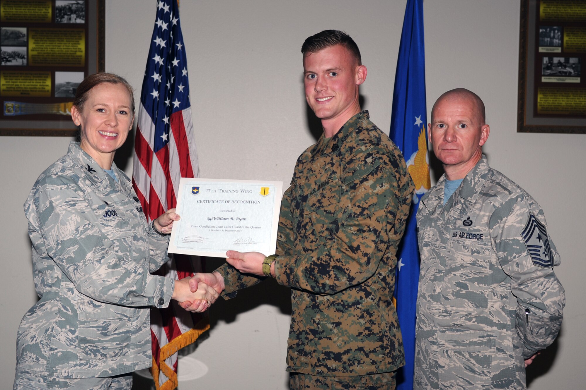 GOODFELLOW AIR FORCE BASE, Texas - Col. Kimberlee P. Joos, 17th Training Wing Commander, and Chief Master Sgt. Thomas F. Good, 17th TRW Command Chief, present the Team Goodfellow Joint Color Guard of the Quarter award to Marine Corps Sgt. William R. Ryan, Marine Corps Detachment Goodfellow, during the wing quarterly awards ceremony at the Event Center Jan. 16. (U.S. Air Force photo/ Staff Sgt. Laura R. McFarlane)