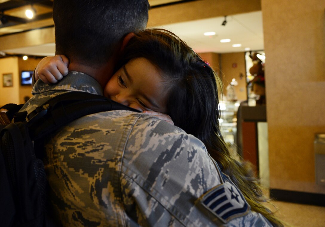 U.S. Air Force Staff Sgt. Robert Calton, 7th Civil Engineer Squadron, hugs his daughter, Cecilia, Jan. 8, 2015, in Abilene, Texas. Calton and other Dyess Airmen said goodbye to their families before departing Abilene Regional Airport for a deployment. (U.S. Air Force photo by Airman 1st Class Kedesha Pennant/Released)