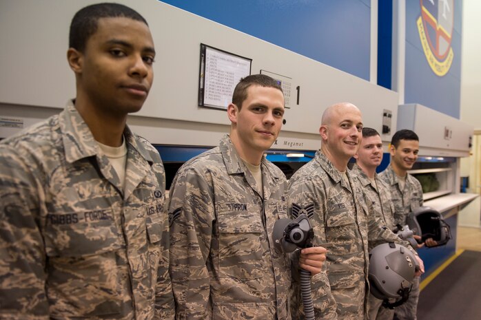Staff Sgt. Shawn Nyer (center) smiles with a group of Airmen Jan. 13, 2015 at Joint Base Charleston, S.C.  Nyer is the 437th Operations Support Squadron Aircrew Flight Equipment NCO in charge of the Aviator Helmet and Mask section. (U.S. Air Force photo/ Senior Airman Jared Trimarchi) 