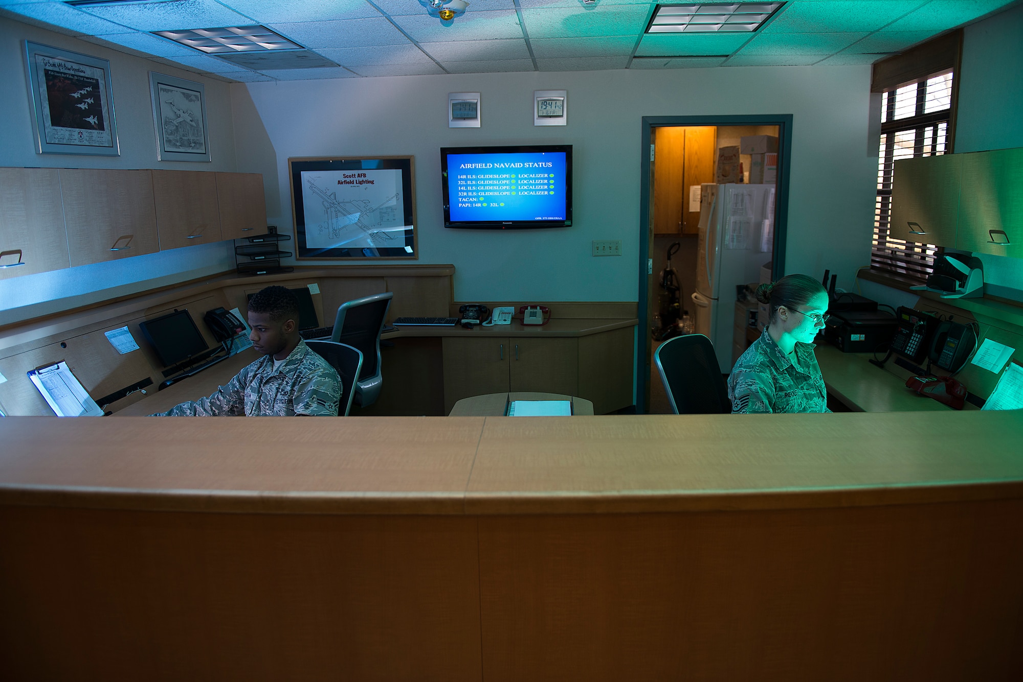 Staff Sgt. Christina Ridolfi, 375 Operation Support Squadron airfield management operations supervisor, and Airman 1st Class Seth Calhoun, 375 OSS airfield management operations coordinator, monitor flight line operations Jan. 16, 2015, at Scott Air Force Base, Ill. The airfield management operations desk provides flight services for all inbound and outbound aircraft, conduct airfield checks, report surface conditions of airfield pavement, conduct airfield inspections, process Notice to Airman, brief home station and transient aircrews on airfield status and restrictions, activate the Secondary Crash Phone (SCN) to pass vital emergency information to support agencies, and respond to airfield emergencies. (U.S. Air Force photo/Senior Airman Joshua Eikren)