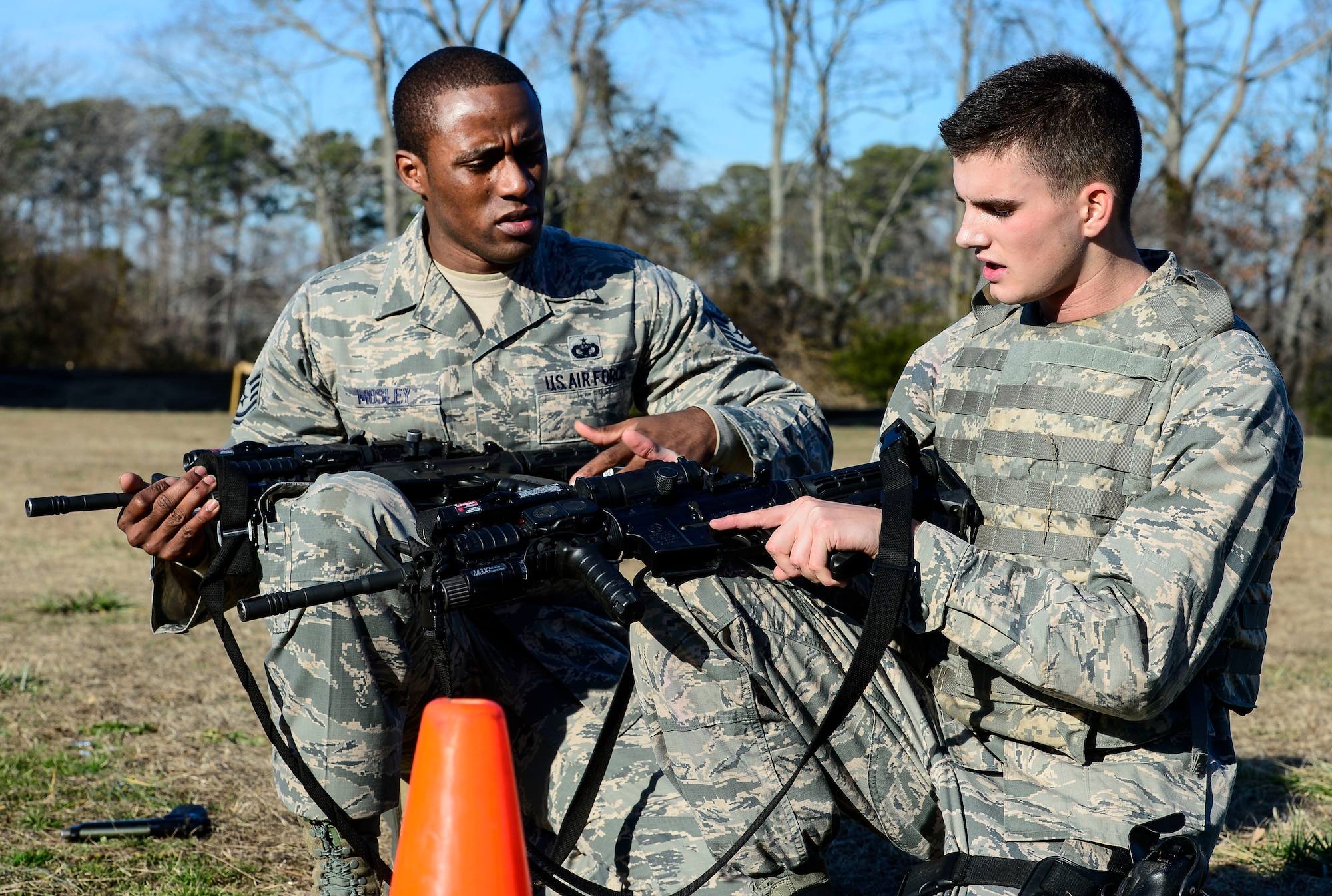 U.S. Air Force Tech. Sgt. Franklin Mosley, 633rd Security Forces Squadron trainer, instructs Airman Dylan Coady, 633rd SFS installation entry controller, on firing the M-4 carbine during emergency service team tryouts at Langley Air Force Base, Va., Jan. 20, 2015. The EST is a specialized element within 633rd SFS that deals with specialized threats at Air Force installations. (U.S. Air Force photo by Senior Airman Kayla Newman/Released) 