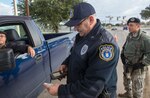 Police Sgt. John Rady, 802nd Security Forces Squadron shift supervisor, and Senior Airman Michael Raynes, 802nd SFS craftsmen, check IDs at the Selfridge Gate Jan. 15 at Joint Base San Antonio-Lackland. (U.S. Air Force photo by Benjamin Faske)