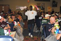 Senior Airman Kristian Smith sells additional bingo cards to guests attending Super Base Extravaganza, Jan. 17, 2015, at the Northern Lights Club on Grand Forks Air Force Base, N.D. Smith was one more than a dozen Airmen who volunteered to make the base’s annual fundraiser a success. (U.S. Air Force photo/Staff Sgt. Luis Loza Gutierrez)