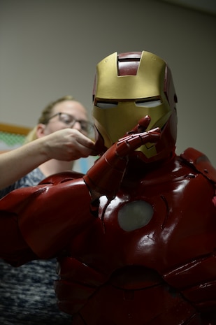 Tech. Sgt. Brian Thornton, 628th Air Base Wing air defense council paralegal, dons his homemade Iron Man suit with the help of his wife, Joy Thornton, Dec. 8, 2014 to visit students at Marrington Elementary, Joint Base Charleston - Weapons Station, S.C. The suit took Thornton ten months to complete and is made out of paper, car bondo, Plexiglas, nuts, bolts and anything else he could find in his garage. Thornton wears his Iron Man suit at local schools and hospitals hoping to help brighten a child’s day. (U.S. Air Force photo/Senior Airman Christopher Reel)