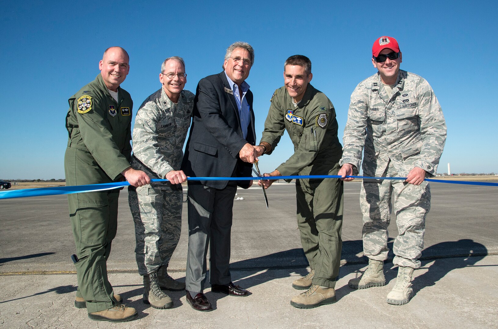 Col. David Drichta, 12th Operations Group commander, Brig. Gen. Bob LaBrutta, 502nd Air Base Wing and Joint Base San Antonio commander, City of Seguin Mayor Don Keil, Col. Matt Isler, 12th Flying Training Wing commander; and Capt. Erich Kramer, 820th Rapid Engineers Deployable Heavy Operational Repair Squadron design engineer cut the ribbon signifying the reopening of the Joint Base San Antonio-Randolph Seguin Auxiliary Airfield Jan. 20.  Upon completion of a three-year construction project, the airfield is now ready for flying by members of the 560th Flying Training Squadron.  The airfield is crucial for “touch and go” training that qualifies fighter and bomber pilots as instructor pilots in the T-38C Talon.  The reconstructed runway increases flight safety by distributing training around the San Antonio area, which means fewer aircraft and less congestion around Joint Base San Antonio-Randolph. (U.S. Air Force photo by Johnny Saldivar)