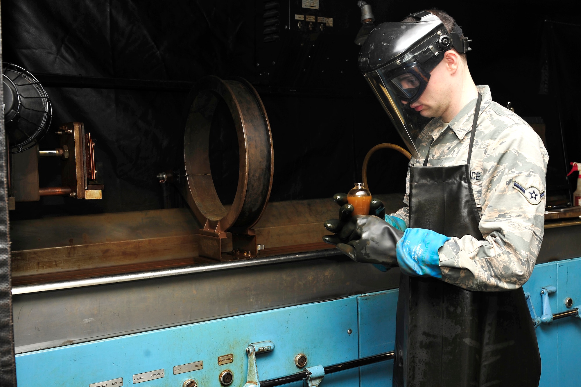 U.S. Air Force Airman William Early, 1st Maintenance Squadron non-destructive inspection apprentice, uses a magnetic partial machine at Langley Air Force Base, Va., Jan. 21, 2015. The magnetic partial machine magnetizes material to find aircraft or supporting part to find defects. (U.S. Air Force photo by Airman 1st Class Breonna Veal/Released) 