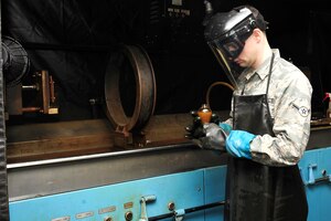 U.S. Air Force Airman William Early, 1st Maintenance Squadron non-destructive inspection apprentice, uses a magnetic partial machine at Langley Air Force Base, Va., Jan. 21, 2015. The magnetic partial machine magnetizes material to find aircraft or supporting part to find defects. (U.S. Air Force photo by Airman 1st Class Breonna Veal/Released) 