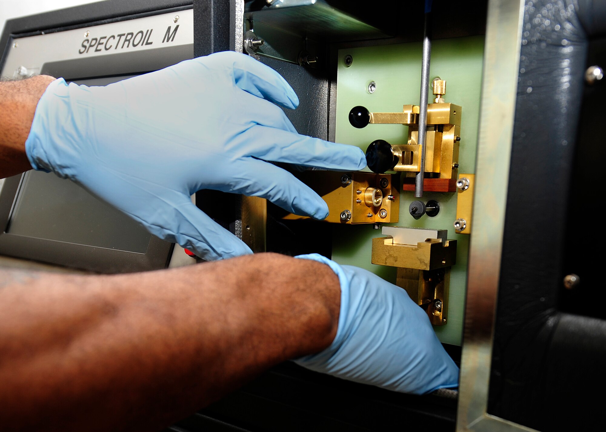 U.S. Air Force Senior Airman Kellyn Harris, 1st Maintenance Squadron non-destructive inspection journeyman, prepares a joint oil analysis program at Langley Air Force Base, Va., Jan. 21, 2015. The joint oil analysis program burns oil samples to ensure an accurate reading of metals in the oil. (U.S. Air Force photo by Airman 1st Class Breonna Veal/Released)