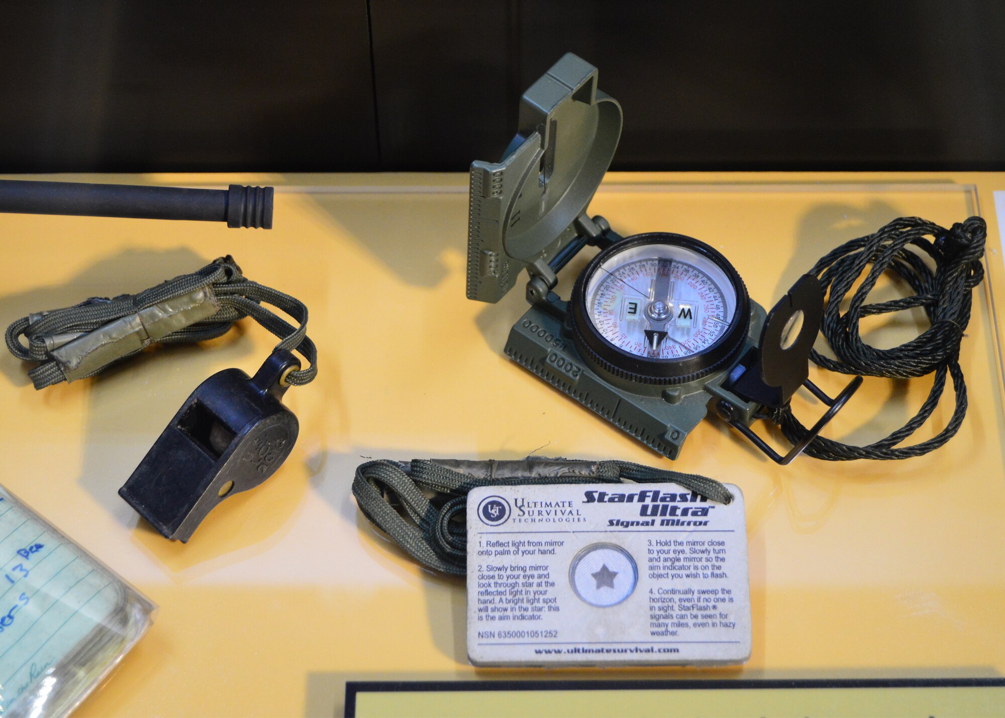 DAYTON, Ohio -- The "Duty First, Always Ready" exhibit, located in the Cold War Gallery at the National Museum of the U.S. Air Force, highlights the service of Senior Airmen Michael Malarsie and Bradley Smith, a two-man Joint Terminal Attack Controller (JTAC) who deployed together to Afghanistan in December 2009. Here are the compass, whistle and signal mirror used by Senior Airman Smith. (U.S. Air Force photo)
