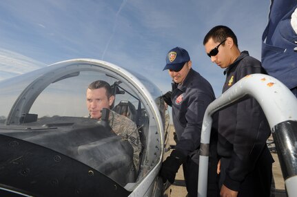 Timothy Hagan and SSgt Daniel Wool, Joint Base San Antonio-Randolph firefighters, trains  Mark Gonzales, a local firefighter from Live Oak Jan. 17, 2015.  Egress training brings together JBSA-Randolph firefighters with local city firefighters to prepare for aircraft emergencies through readiness training.  (U.S. Air Force photo by Melissa Peterson)