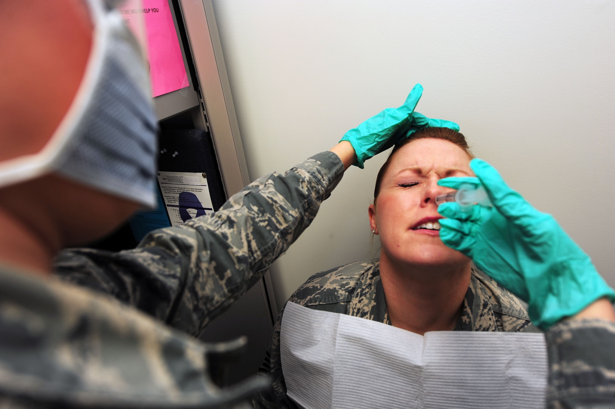 Airman 1st Class Amy Ornelas, 42nd Medical Group, Team Eagle, medical technician, administers a saline solution into the nose of Staff Sgt. Melissa Hay, 42nd Air Base Wing Public Affairs broadcaster, Jan. 16, 2015 at the 42 MDG Ambulatory Health Care Center, Maxwell Air Force Base, Alabama. The solution is administered into the nose of patients exhibiting signs of the flu and provides accurate diagnosis for influenza. Dubbed "Project Gargle" the comprehensive test results are inputted into a database that helps build the flu vaccine for next year. (U.S. Air Force photo by/Staff Sgt. Erica Picariello/Cleared)
