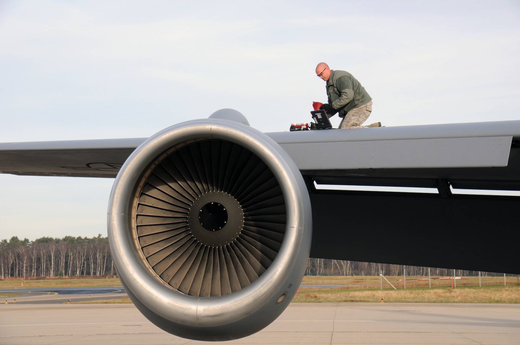 Senior Airman Josh Wasden, a crew chief with the 151st Maintenance Group, adds hydraulic fluid to a KC-135R Stratotanker on Jan. 6, 2015. (Air National Guard photo by Staff Sgt. Annie Edwards/RELEASED)