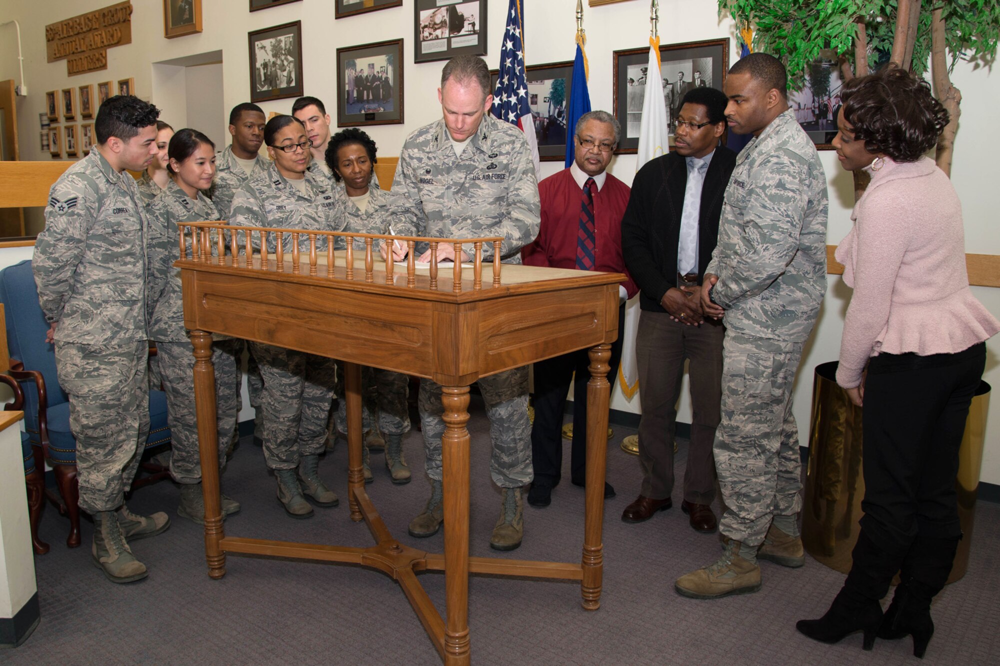 Col. Michael A. Vogel, 66th Air Base Group commander, signs a proclamation declaring the month of February as African American History Month as members of the committee look on Jan. 20 in the Brown Building lobby. There will be several events held throughout the month to commemorate the theme, “A Century of Black Life, History and Culture.” (U.S. Air Force photo by Mark Herlihy)