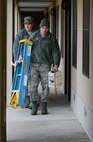 Senior Airman David Ulman and Staff Sgt. Jordan Weaver, 436th Civil Engineer Squadron, Heating, Ventilation, and Air Conditioning section, move to their next location while troubleshooting a heating problem in Dorm 430 on Jan. 15, 2015, at Dover Air Force Base, Del. The pair has to flush individual heating units to allow fresh heated water to be cycled through them. (U.S. Air Force photo/Greg L. Davis)