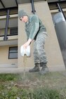 Senior Airman David Ulman, 436th Civil Engineer Squadron, Heating, Ventilation, and Air conditioning section, pours dirty water from a heater unit out on the ground near Dorm 430 while troubleshooting a problem on Jan. 15, 2015, at Dover Air Force Base, Del. Trapped water inside the heater unit didn't allow heat to be transferred by the unit. (U.S. Air Force photo/Greg L. Davis)