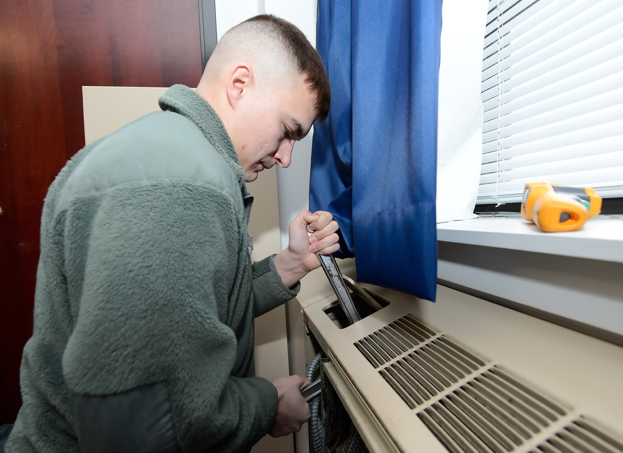 Senior Airman David Ulman, 436th Civil Engineer Squadron, Heating, Ventilation, and Air conditioning section, uses two wrenches to open a valve on a heater unit inside of Dorm 430 while troubleshooting a problem on Jan. 15, 2015, at Dover Air Force Base, Del.  (U.S. Air Force photo/Greg L. Davis)