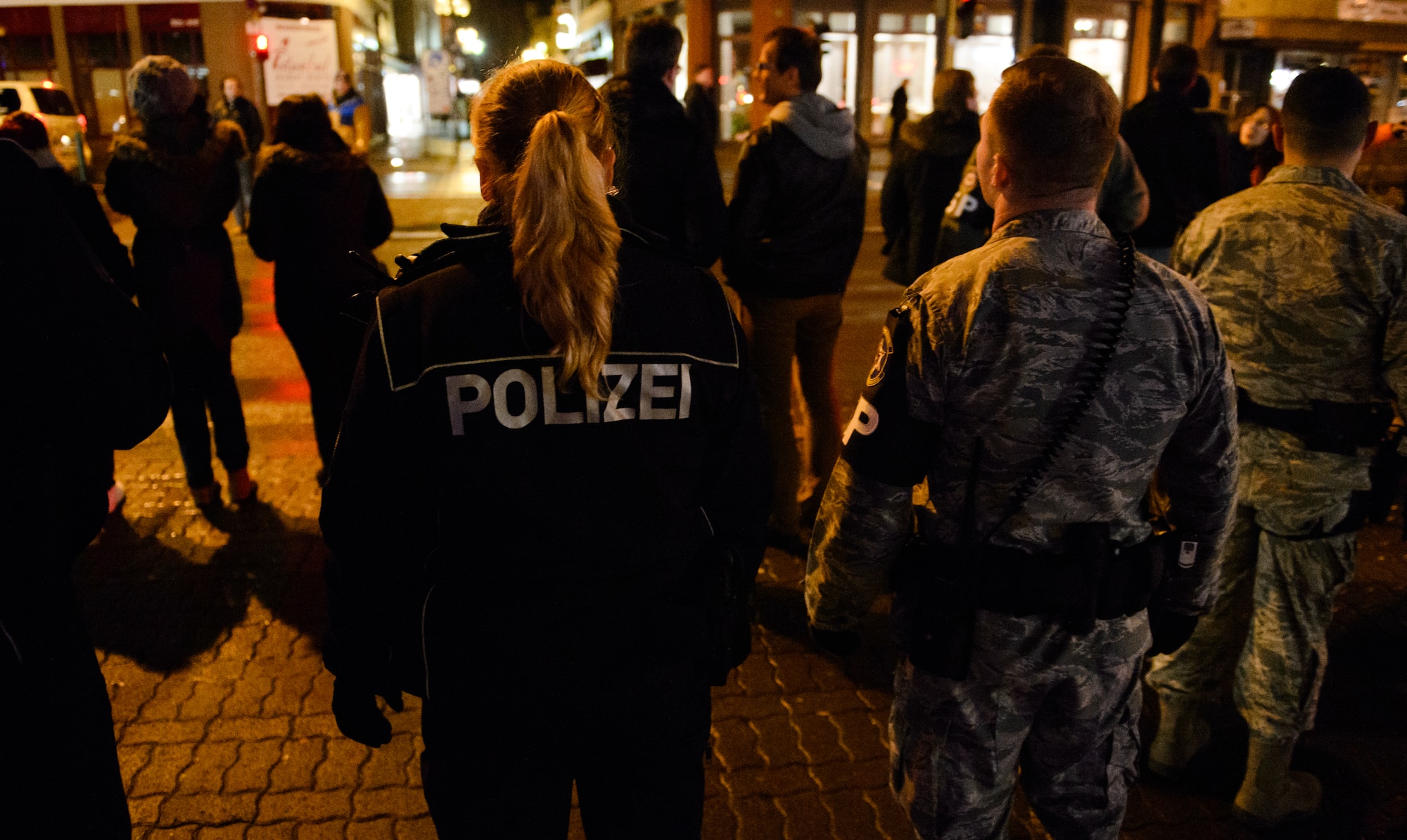 Airmen from the 569th U.S. Forces Police Squadron and Polizei patrol the streets and are surrounded by large amounts American and German party goers in downtown Kaiserslautern, Germany, Jan. 17, 2014. The two are part of a joint patrol designed to promote better relations, ensure security and law enforcement for the area. (U.S. Air Force photo/ Senior Airman Armando A. Schwier-Morales)