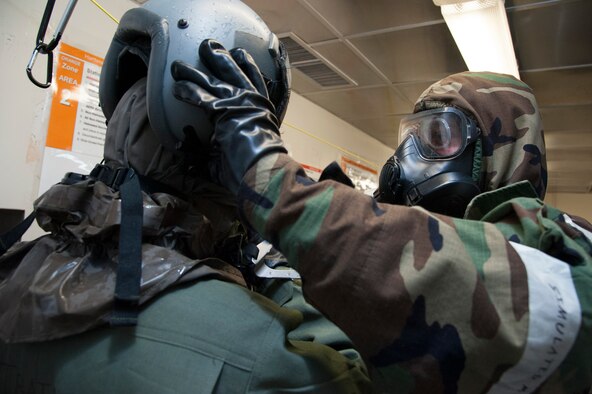 Airman 1st Class Steven Snyder, 51 Operations Support Squadron aircrew flight equipment journyman, performs Aircrew Contamination Control Area processing training with Staff Sgt. Leshane Jackson, 51 OSS aircraft flight equipment craftsman and acting pilot, at Osan Air Base, Republic of Korea, Jan. 16, 2015. The ACCA line is a special chemical contamination processing line where aircrew members would have to process through after a flight if chemical agents are suspected to be present in the area. (U.S. Air Force photo by Senior Airman Matthew Lancaster)